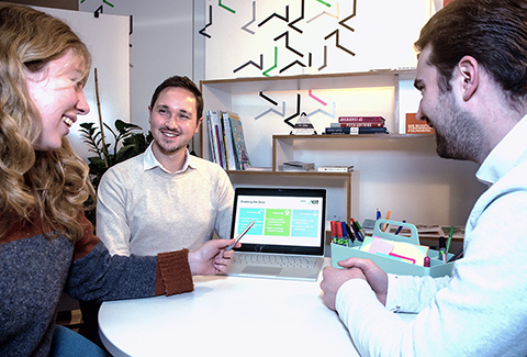 Three students at a laptop